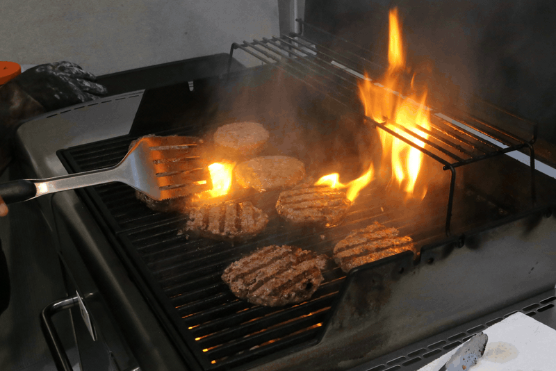 Burgers on the grill, flames doing their thing